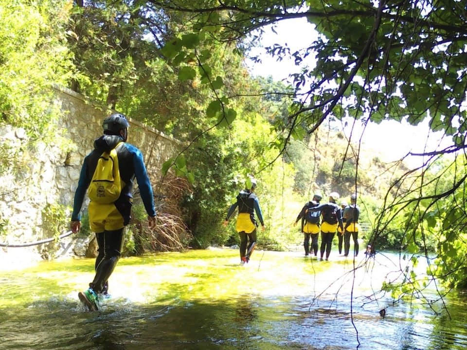 Canyoning group wading a river gorge nearby